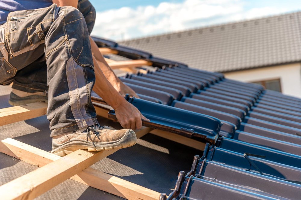 A worker installing standing-seam metal roof panels