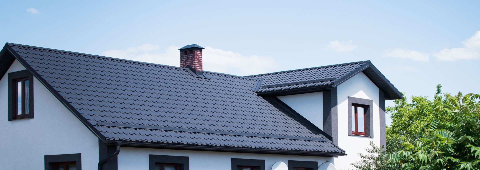 A South Florida home with a freshly installed dark tile roof against a blue sky