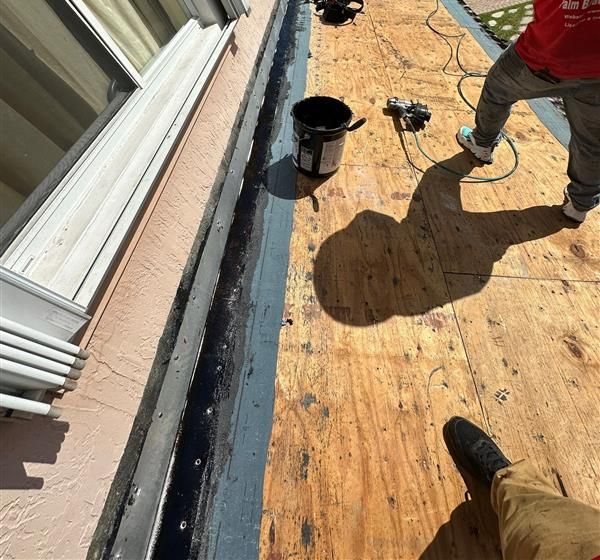 A technician sealing flashing and underlayment during a roof repair